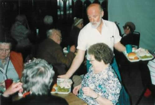 Pastor Paul S Arnopoulos serving lunch to seniors on Senior's Day.