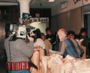 Pastor Paul S Arnopoulos distributing grocery bags at the Thanksgiving GiveAway in 1986.