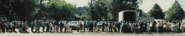 Long lines of people waithing for food at Street GiveAway in South Minneapolis.